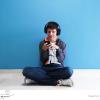 picture of a teenager with autism sat on his phone with headphones on