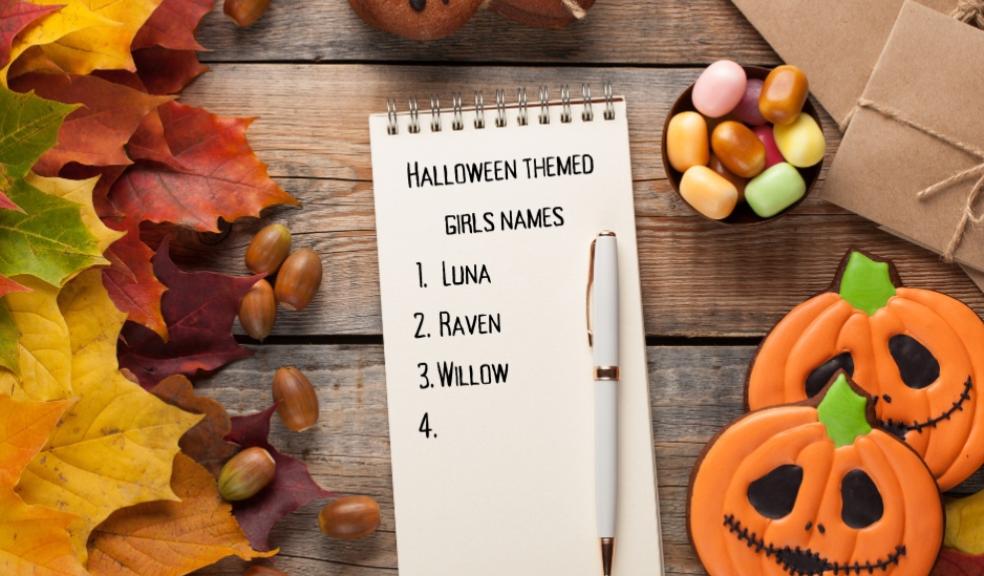 picture of Halloween themed girls names written on a notepad with Halloween decor