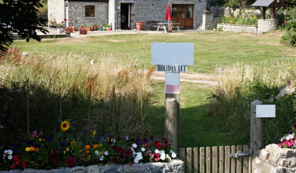 picture of a holiday home with holiday let sign in the garden