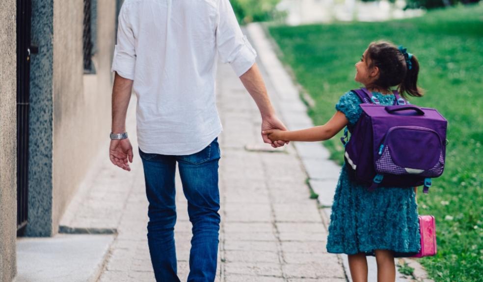 picture of a dad walking his daughter to school