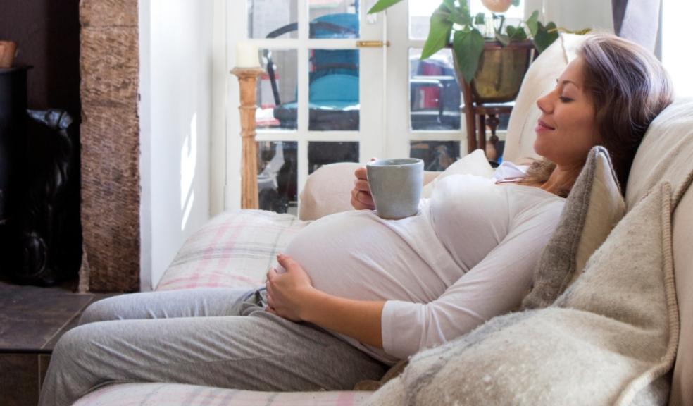 picture of a happy pregnant woman relaxing on the sofa