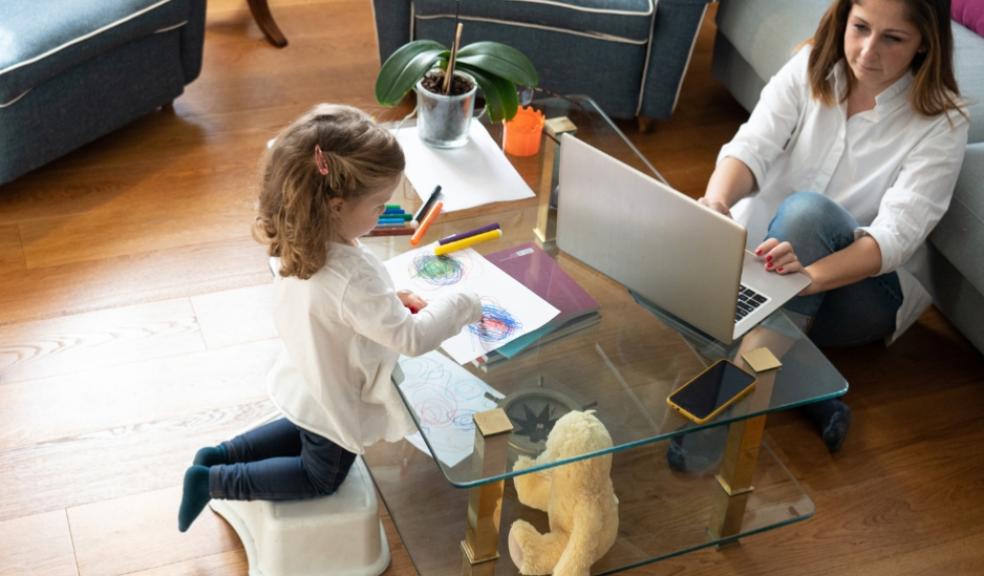 picture of a mum working from home with a child colouring