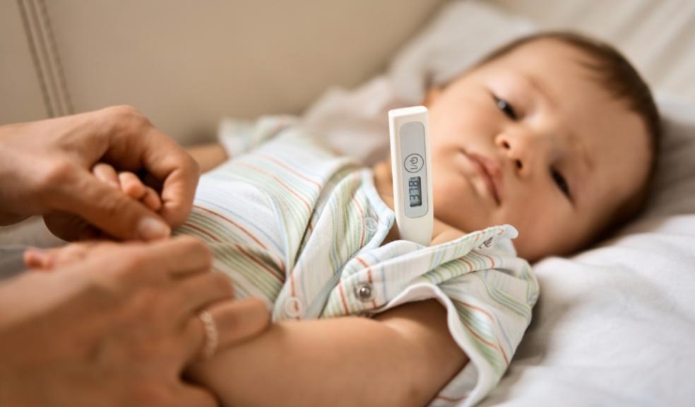 picture of an unwell child having his temperature checked