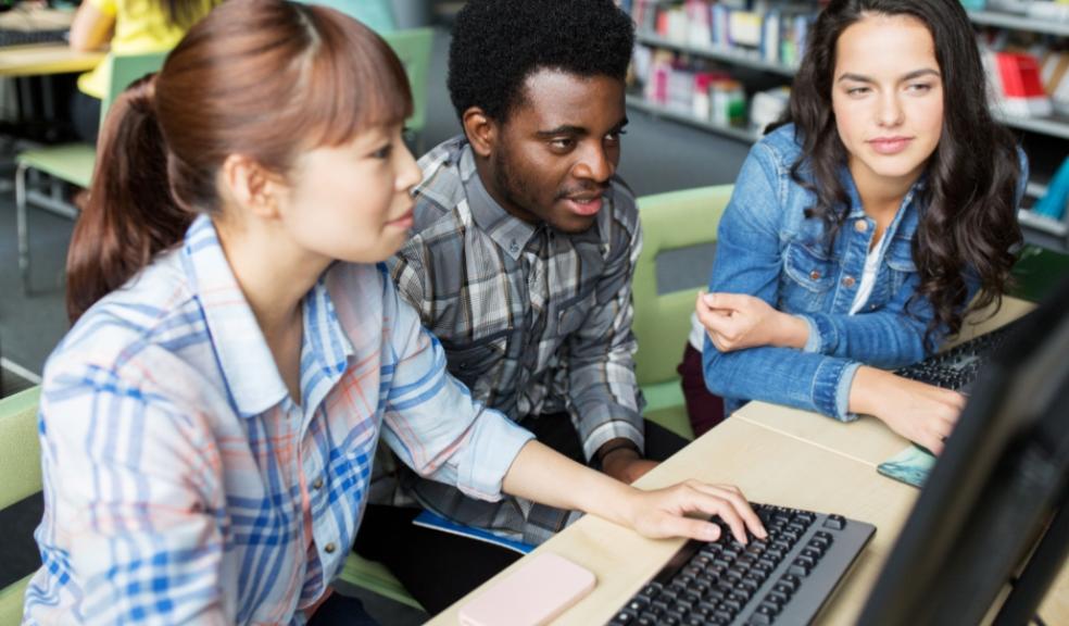 picture of teenagers using a computer in a library