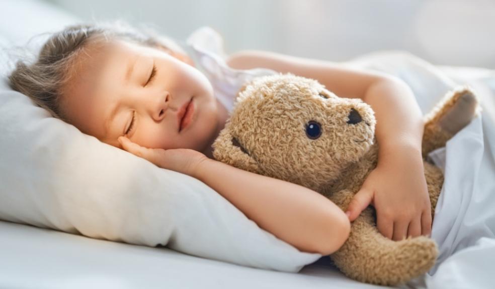 picture of a child asleep cuddling a tedding bear