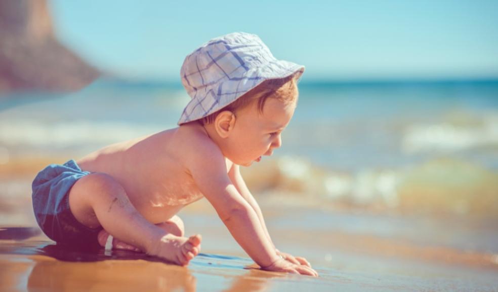 picture of a baby on a beach on a sunny day