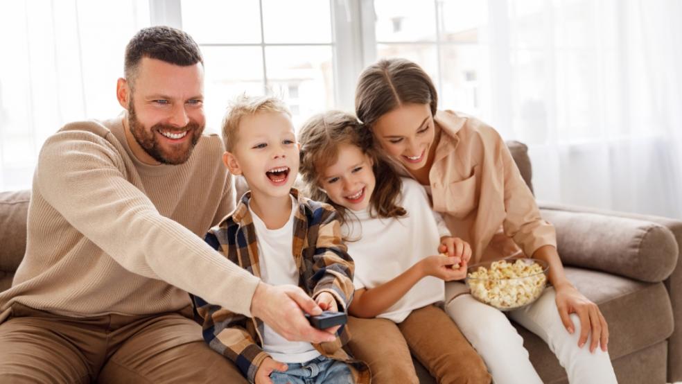 picture of happy family sat watching tv