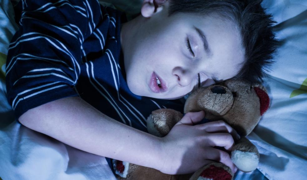 picture of a child sleeping with a teddy bear