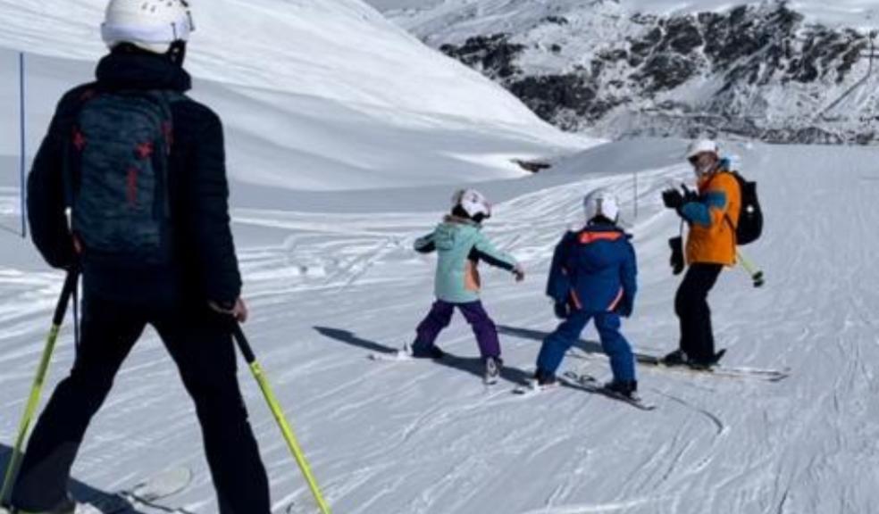 picture of a family skiing down the mountain on their first ski holiday 