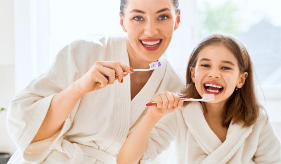 picture of a happy mum and daughter brushing their teeth together