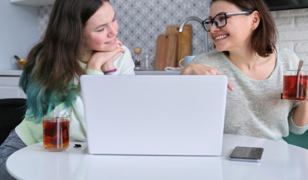 picture of a parent and teenager in the kitchen with a laptop