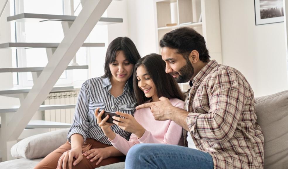 picture of parents looking at child on a smartphone