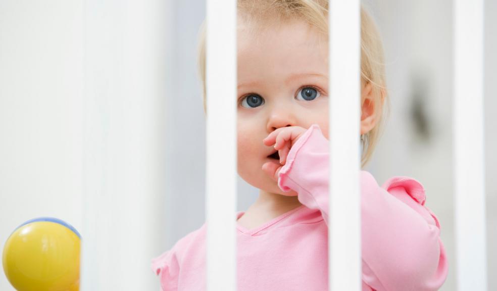 Child stood behind a stair gate