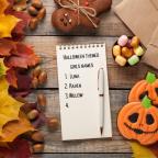 picture of Halloween themed girls names written on a notepad with Halloween decor