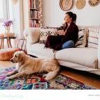 picture of a woman relaxing on a sofa with her golden retriever dog