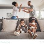 picture of children on the sofa with parents arguing behind them