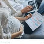 picture of a couple planning for maternity leave with a calendar and laptop