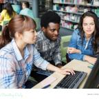 picture of teenagers using a computer in a library