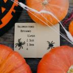 picture of Halloween themed Boys names written on Halloween note paper surrounded by pumpkins