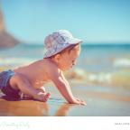 picture of a baby on a beach on a sunny day