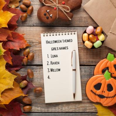 picture of Halloween themed girls names written on a notepad with Halloween decor