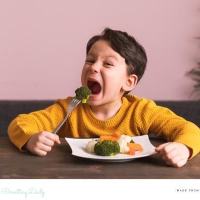 picture of a child eating a plate of vegetables