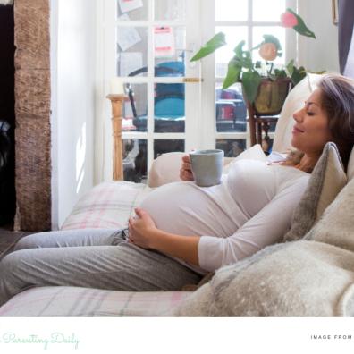 picture of a happy pregnant woman relaxing on the sofa