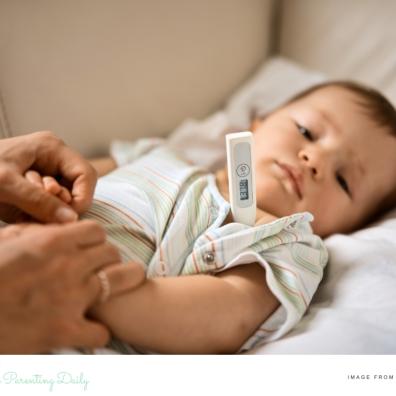 picture of an unwell child having his temperature checked