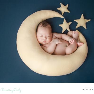 picture of a capricorn baby laying on a moon shaped cushion surrounded by stars