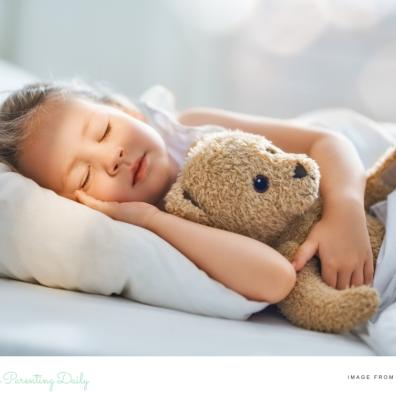 picture of a child asleep cuddling a tedding bear