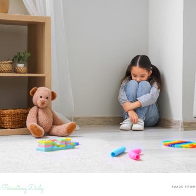 picture of an autstic girl sat in a corner masking her symptoms