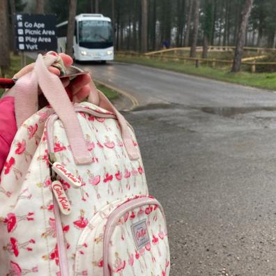 picture of mum holding up a bag in front of a coach